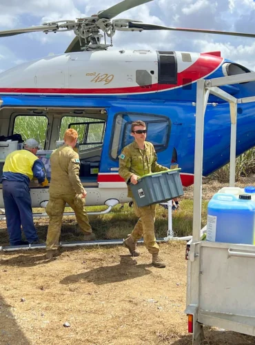 Personnel loading supplies into a Blesk helicopter during flood support